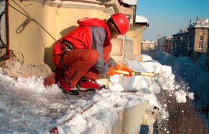 Чистка сугробов с крыши у одного из домов Куровского